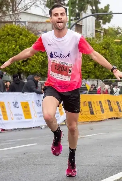 Manuel Jesús Cabezas cruzando una carrera con la camiseta de +Salud